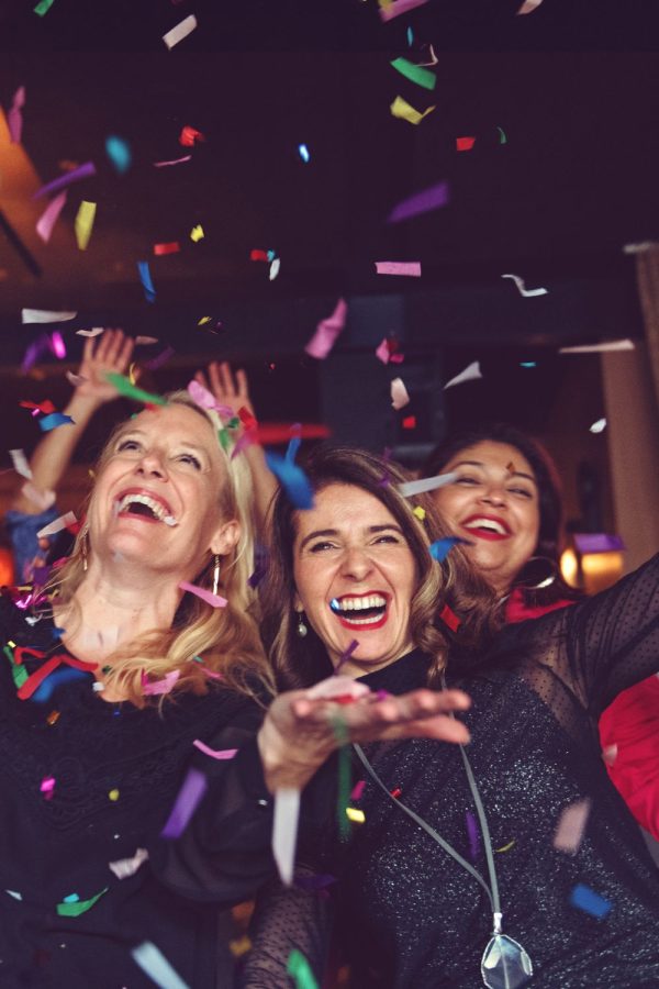 new years eve party ideas - friends smiling and throwing confetti